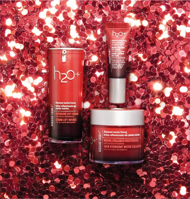 A styled photo of a skin care collection on a background of festive red holiday sparkles.